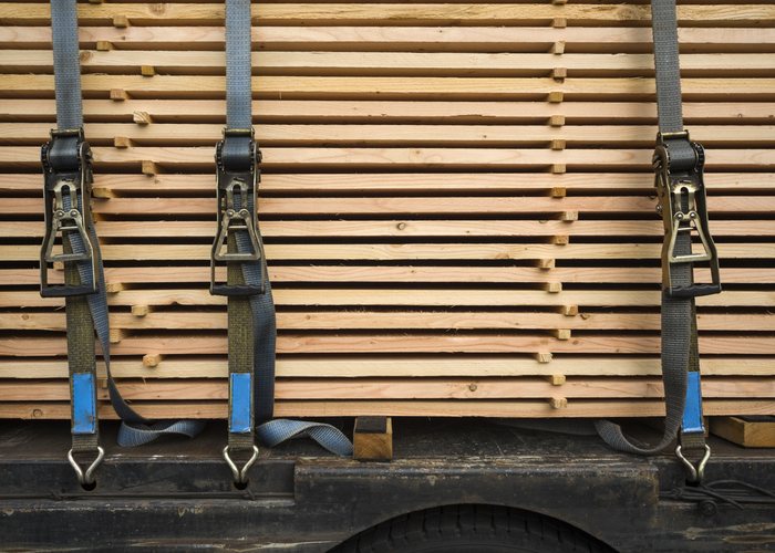Ratchet straps securing a load of timber on a truck deck